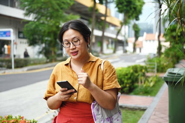 Woman using phone to build website.