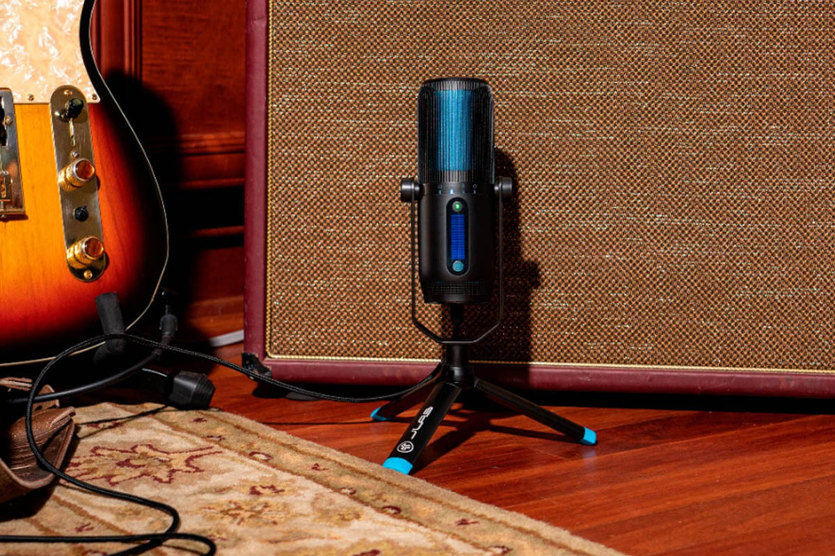 Microphone next to guitar and speaker.