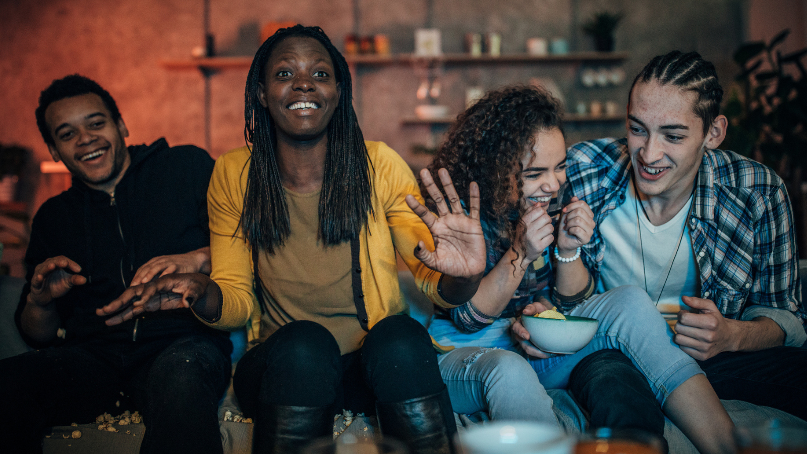 Multi-ethnic friends watching TV - stock photo