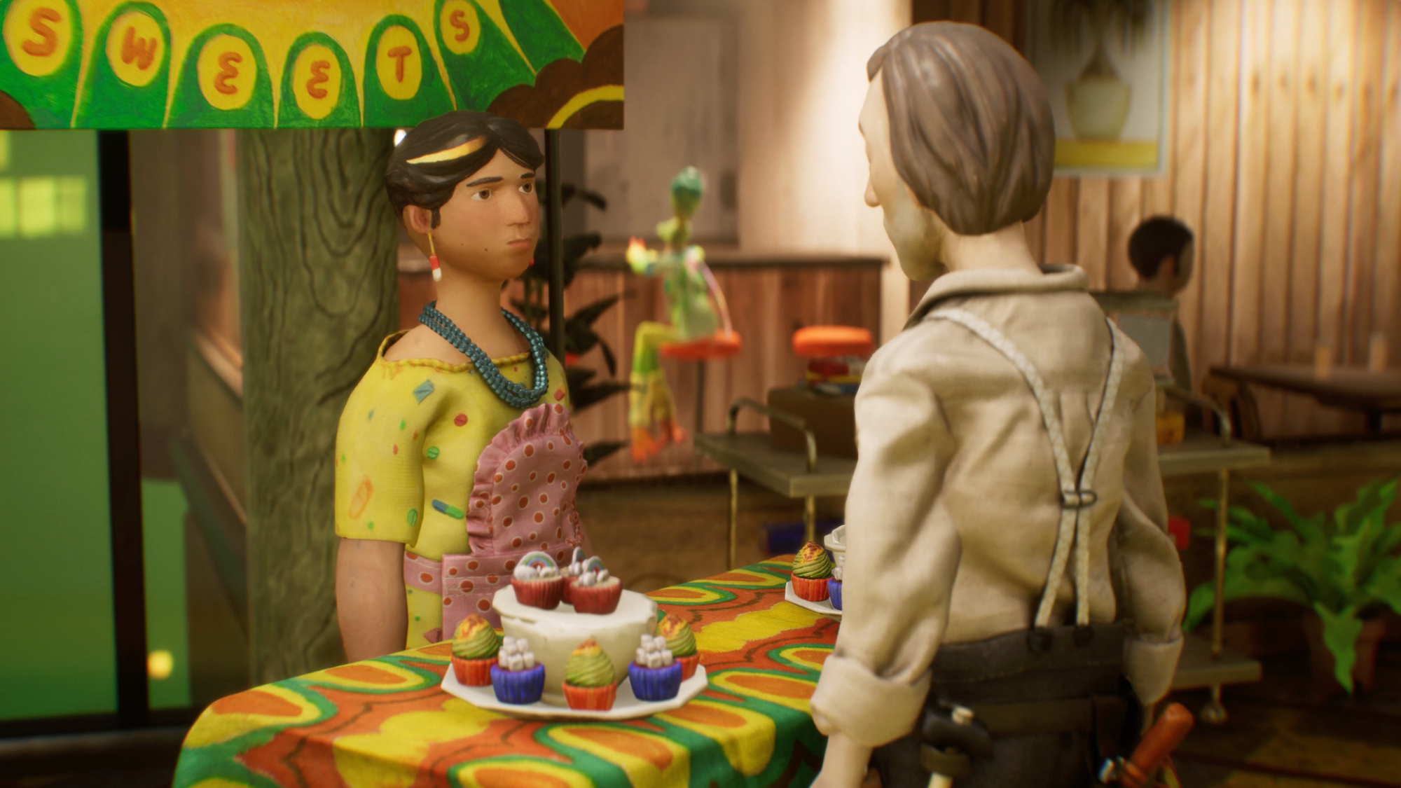 A brightly colored image of two characters at a sweet stand with cupcakes on a table, in a room with lush green plants and a translucent figure in the background.