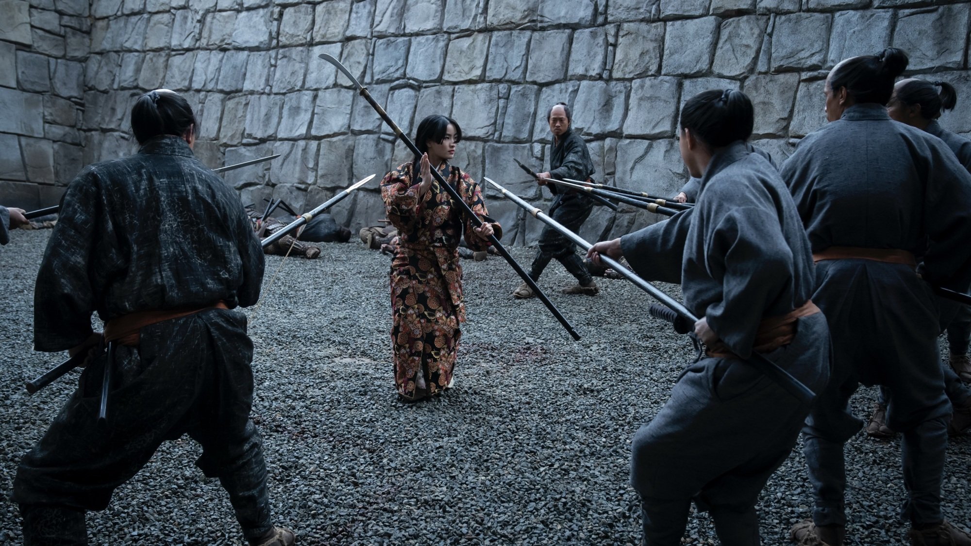 Mariko from "Shōgun" wields a staff while surrounded by soldiers.