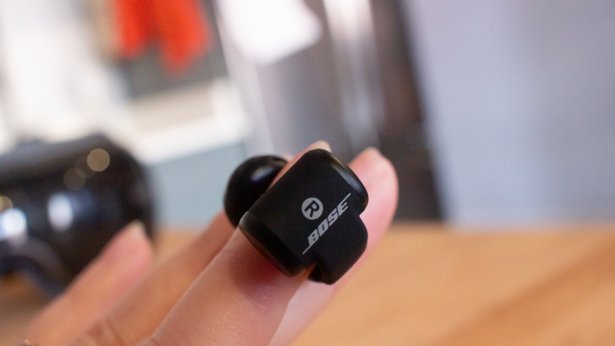 bose ultra open earbud on fingertip